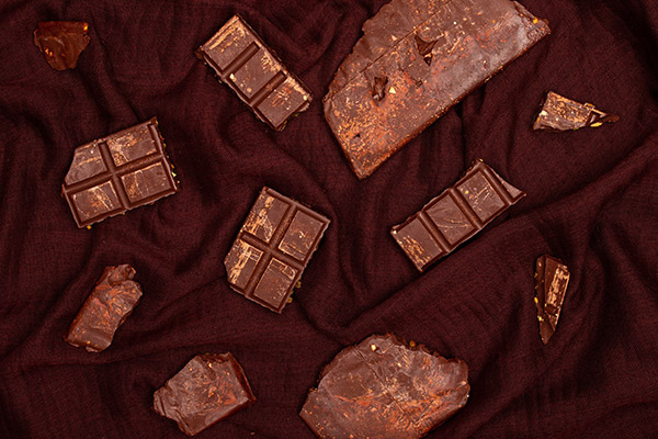 chocolat et morceau de tablette de chocolat sur fond chocolat