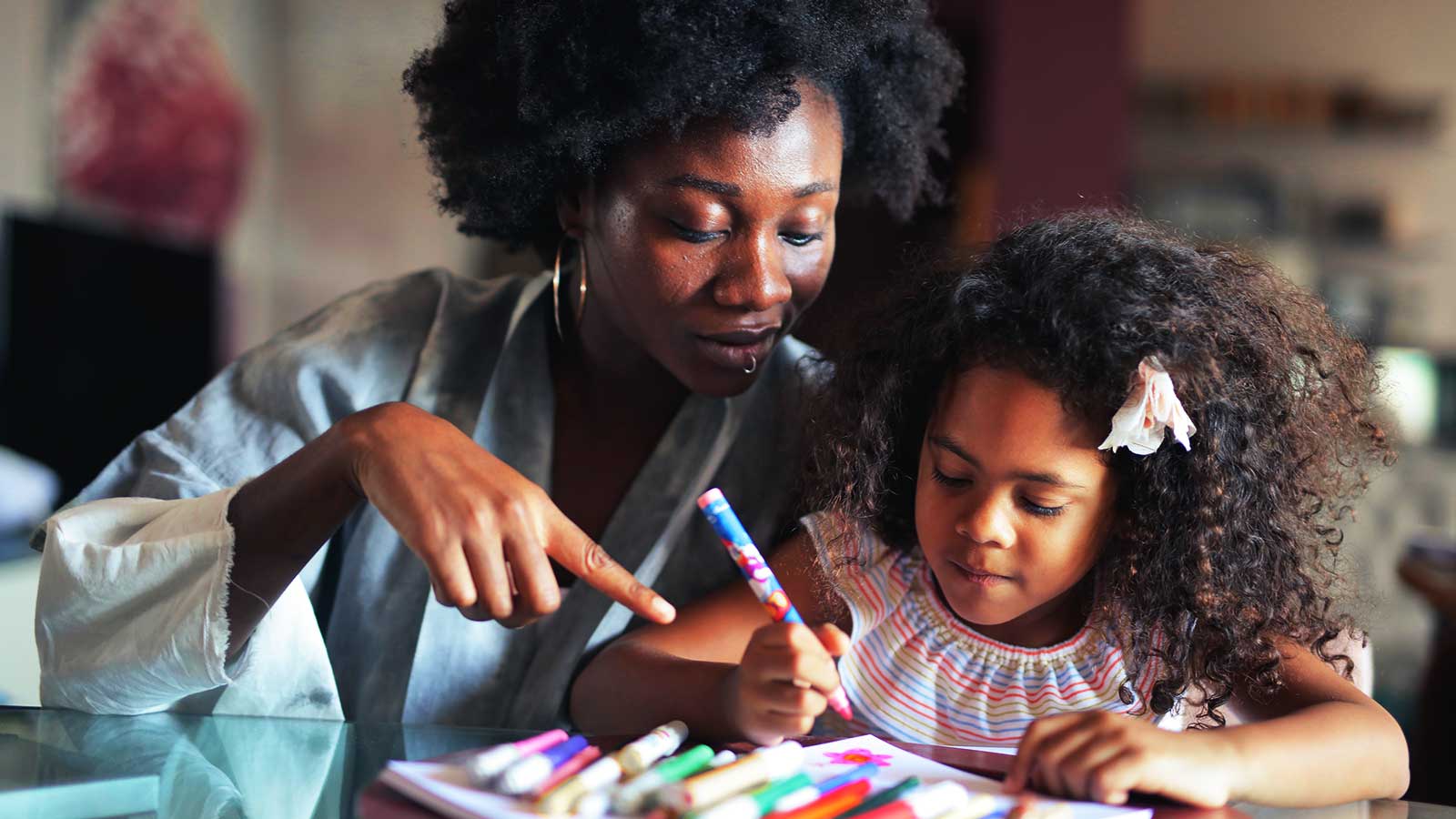 Educatrice avec une jeune élève qui font des travaux de dessin