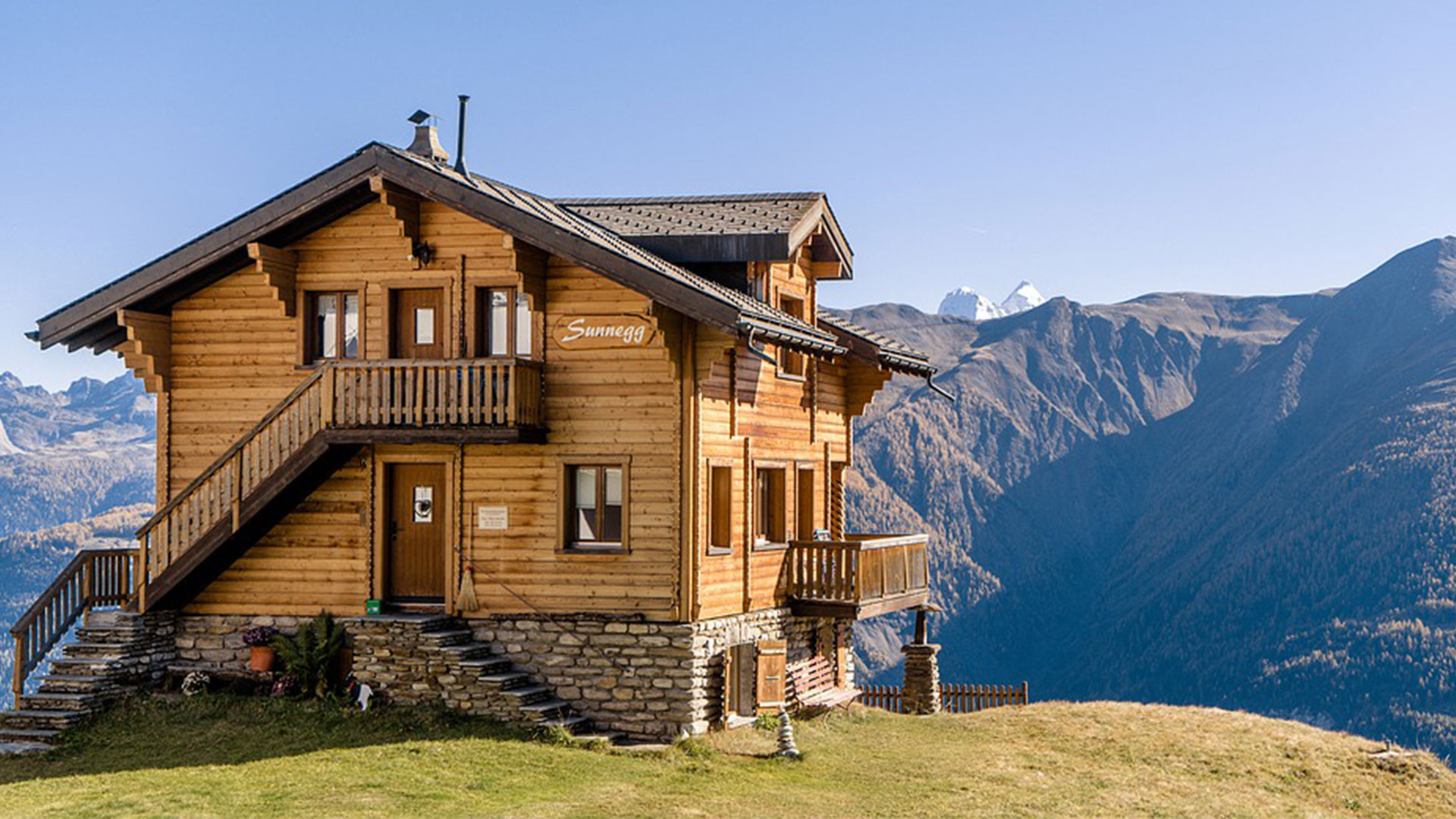 Cette image représente un chalet en bois dans la montagne. 