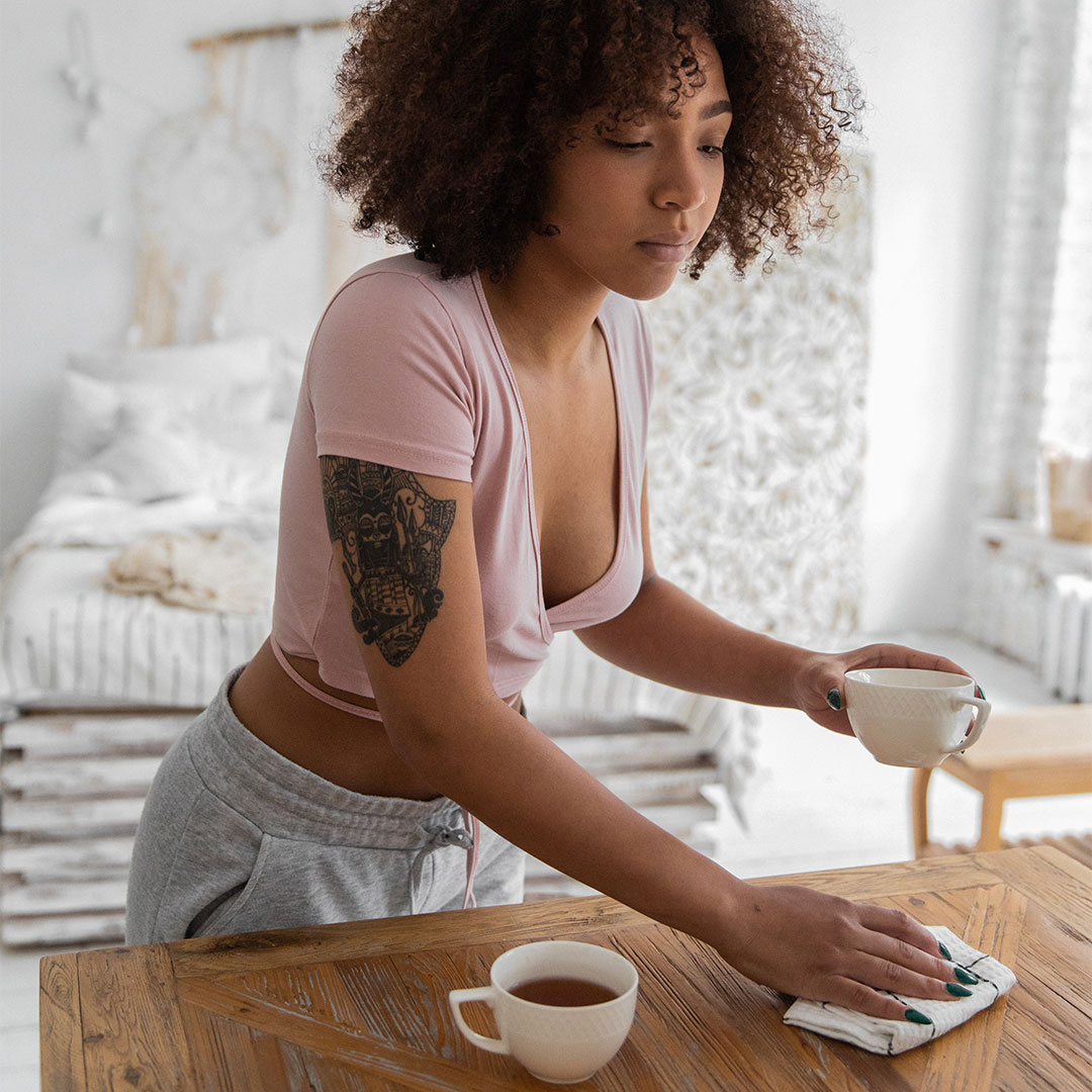 La femme prends sa tasse de café sur la table, tiens la tasse de café et nettoie la table. 