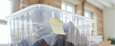 Un panier contenant des vêtements et avec écrit "Donation" sur un post-it.