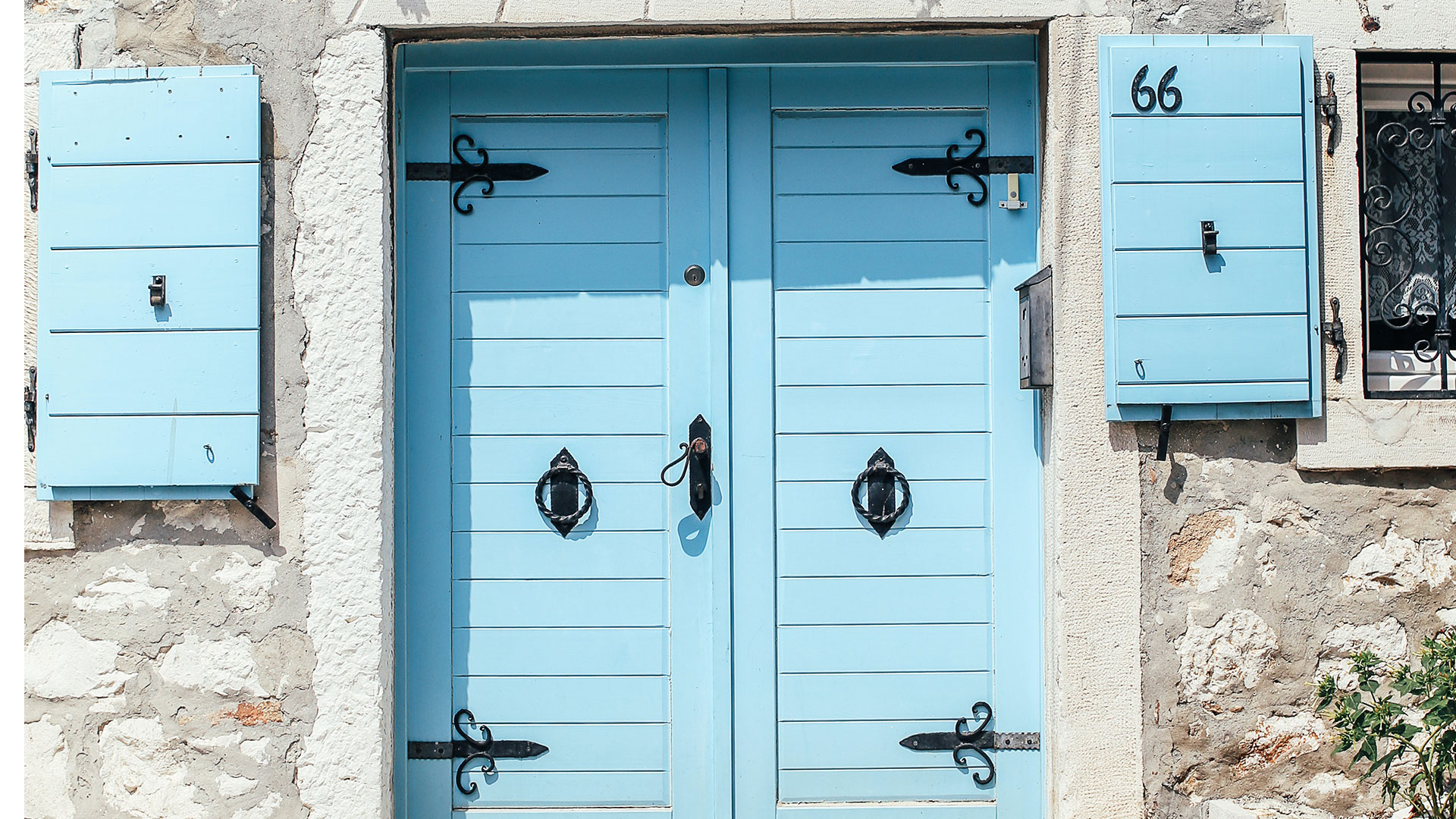 Une porte bleue et des volets bleus 