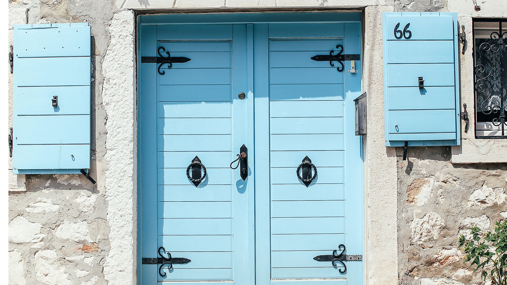 Une porte bleue et des volets bleus