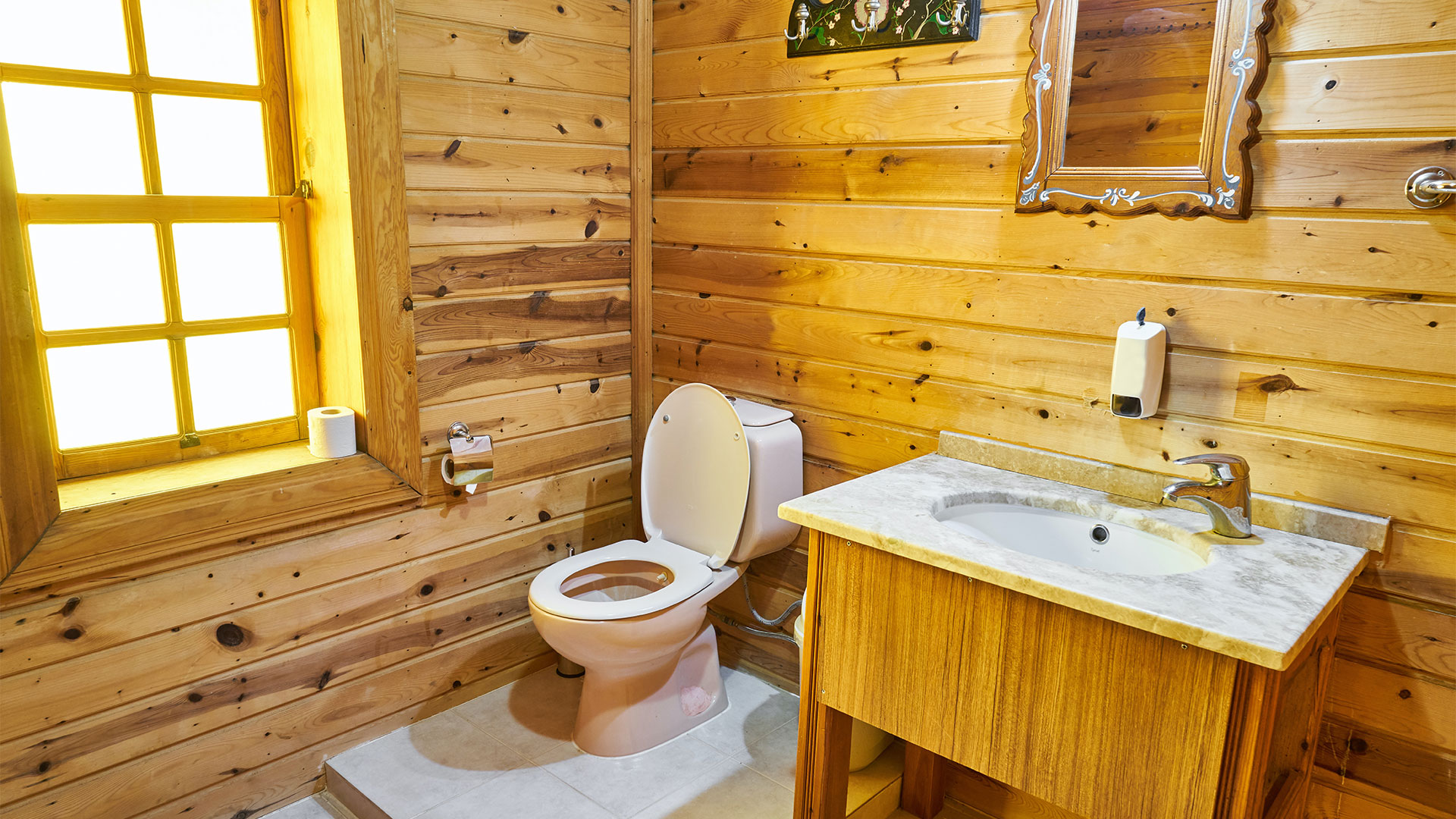 Une image représentant un toilettes dans un contour en bois.