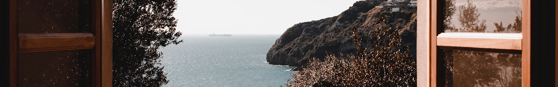 Une image qui montre un paysage à travers une fenêtre. 