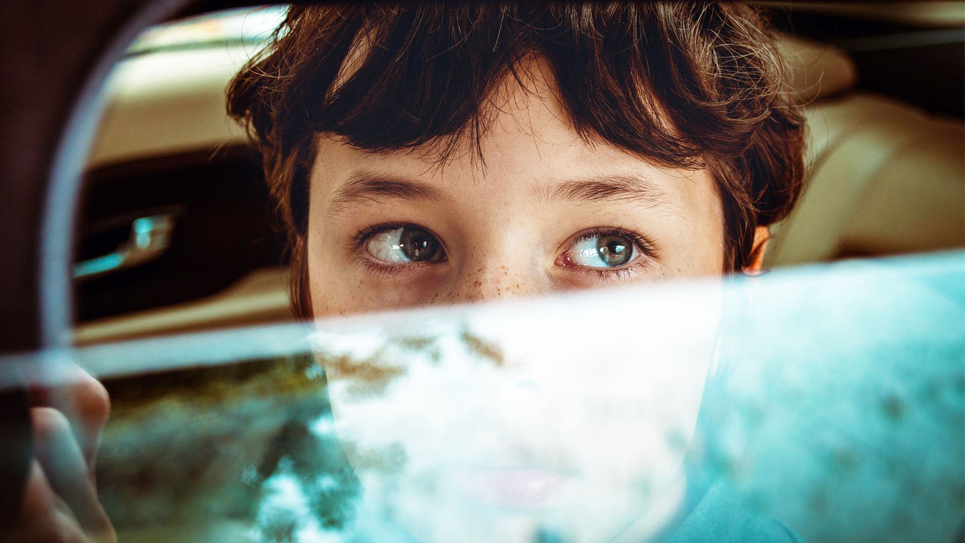 un enfant dans une voiture avec la fenêtre à moitié ouverte