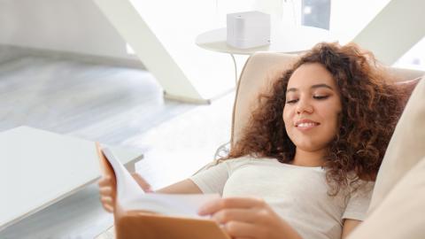 Jeune femme détendu dans un sofa avec un diffuseur ventury sur la table