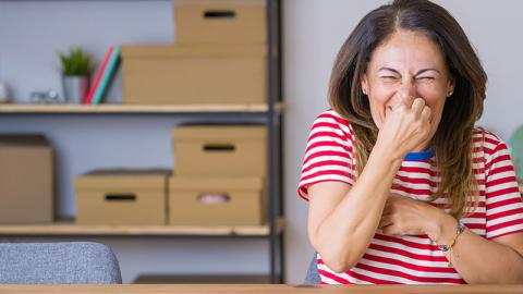 femme dans salle de classe se tien le nez contre les mauvaise odeurs