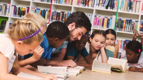 groupe de jeunes élèves lisent avec leur professeurs