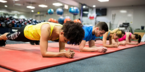 salle de fitness, homme et femme en gainage sur tapis rouge
